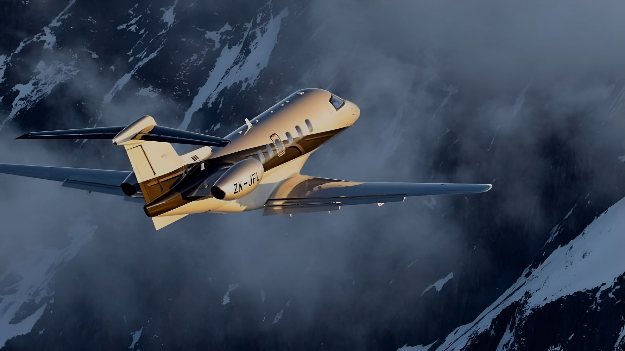 Private jet flying over snow-covered mountains